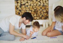 Rodzina rysująca razem na podłodze w salonie